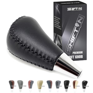 May include: Black leather shift knob with silver base and stitching detail. The product is displayed with its packaging, which features the brand name "SHIFT'N" and the words "PREMIUM SHIFT KNOB". Several color options are shown below.