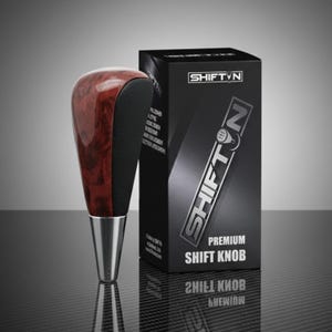 May include: A premium shift knob with a wood grain top and black leather sides, and a polished metal base. The product is displayed next to a black box with the text "SHIFT N PREMIUM SHIFT KNOB".