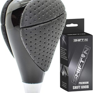 May include: Black leather and chrome gear shift knob with a perforated leather design. The knob is packaged in a black box with the brand name "SHIFT'N" and the text "Premium Shift Knob".