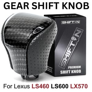 May include: A black gear shift knob with a glossy carbon fiber top and perforated leather sides. The knob is positioned next to a black product box labeled SHIFTN. Text on the image reads GEAR SHIFT KNOB For Lexus LS460 LS600 LX570.
