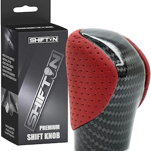 May include: Red and black leather shift knob with a carbon fiber pattern. The knob has a perforated leather design and is labeled "SHIFTIN PREMIUM SHIFT KNOB".