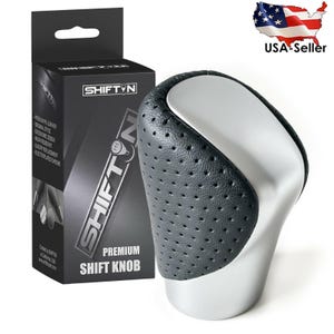May include: A premium shift knob with a perforated black leather grip and a silver base. The product is packaged in a black box with the "SHIFT N" logo and product details. The box also states "Premium Shift Knob".