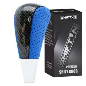 May include: A premium shift knob with a carbon fiber top and blue perforated sides. The knob has a white base and is next to a black box with the "SHIFTIN" logo and "PREMIUM SHIFT KNOB" text.