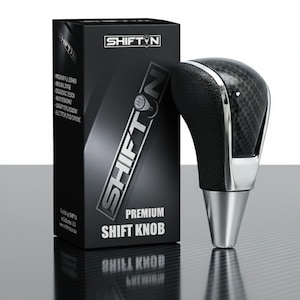May include: A premium shift knob with a carbon fiber design and a silver base. The black box next to it has the text "SHIFT N" and "PREMIUM SHIFT KNOB". The box also lists features like "ORIGINAL STYLE" and "ERGONOMIC DESIGN".