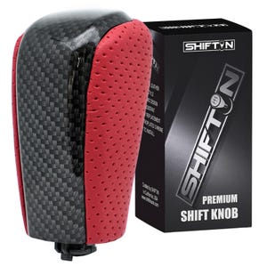 May include: A premium shift knob with a carbon fiber and red leather design. The shift knob is next to a black box with the text "SHIFT N" and "PREMIUM SHIFT KNOB".