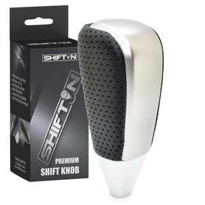 May include: A premium shift knob with a black, perforated leather grip and a silver top. The product is packaged in a black box with the "SHIFTN" logo and product details. The shift knob has a white base.