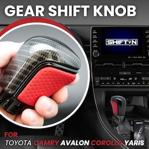 May include: A gear shift knob featuring a carbon fiber pattern top and a textured red leather-like side panel. The text GEAR SHIFT KNOB is at the top, and FOR TOYOTA CAMRY AVALON COROLLA YARIS is at the bottom. A SHIFT N logo is on the car screen.
