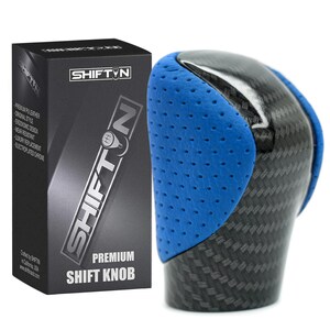 May include: A premium shift knob with a carbon fiber design and blue perforated leather accents. The product is packaged in a black box with the "SHIFTIN" logo and product information.