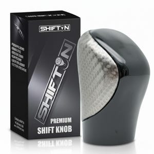 May include: A black and silver premium shift knob with a textured silver panel and glossy black finish. The shift knob is next to a black box with the brand name "SHIFT N" and product details.