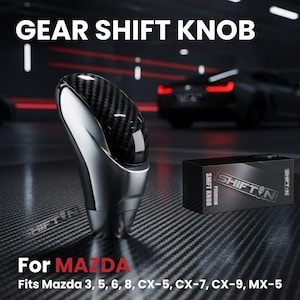 May include: A gear shift knob with a carbon fiber top and a silver base. The text "GEAR SHIFT KNOB" is at the top. The text "For MAZDA" is at the bottom, with a list of compatible Mazda models. A black box with the text "SHIFT KNOB" is also visible.