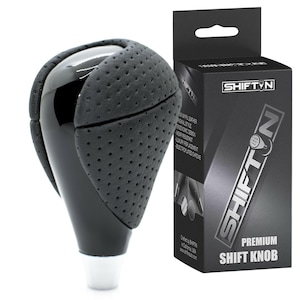 May include: A black and gray shift knob with a perforated leather grip and a glossy top. The product is packaged in a black box with the text "SHIFTIN" and "PREMIUM SHIFT KNOB".