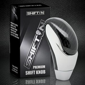May include: A premium shift knob with a black and silver design. The shift knob has a glossy black top and a white and silver base. The product is packaged in a black box with the "SHIFT N" logo and product details.