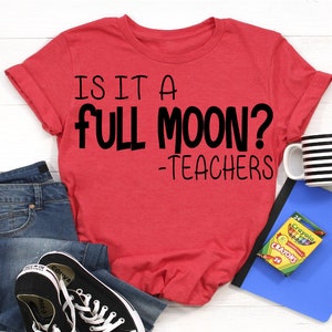 Pode incluir: Camiseta vermelha com o texto "Is it a full moon? -Teachers" em letras pretas.