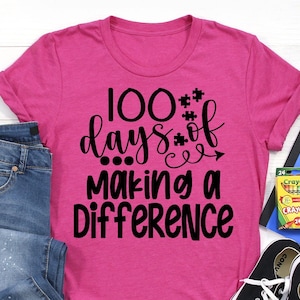 May include: Pink t-shirt with black text that reads "100 days of making a difference".