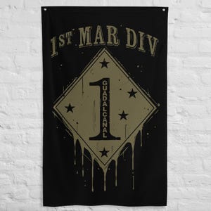May include: Black flag with a tan diamond shape containing the number "1" and the text "GUADALCANAL". The diamond is surrounded by five stars. The text "1ST MAR DIV" is at the top of the flag.