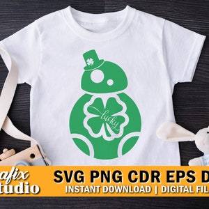 May include: A white t-shirt with a green and white graphic of a Star Wars character, R2-D2, with a four-leaf clover and the word "lucky" on it. The graphic is in the center of the shirt.