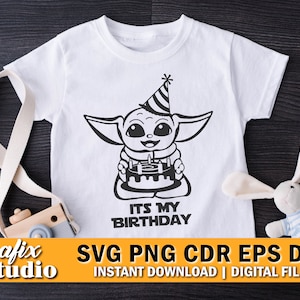 May include: A white t-shirt featuring a black and white illustration of a baby Yoda character wearing a party hat and holding a birthday cake. The text "It's My Birthday" is printed below the illustration.
