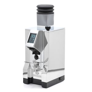 Puede incluir: Un molinillo de caf&eacute; plateado con una parte superior negra y una pantalla digital. El molinillo tiene una base negra y el texto "SPECIALITA" en la parte delantera.