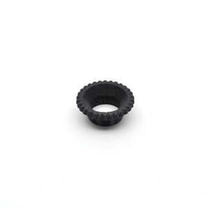May include: A black plastic ring with a textured outer edge and a smooth inner surface.