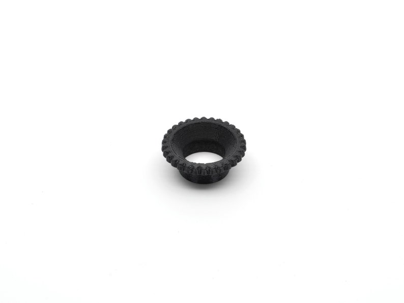 May include: A black plastic ring with a textured outer edge and a smooth inner surface.