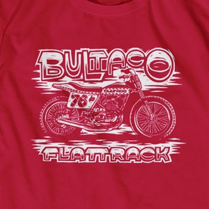 Puede incluir: Camiseta roja con un gráfico blanco de una motocicleta Bultaco vintage con el texto "Bultaco Flattrack" debajo.