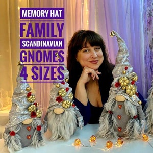 Può includere: Una famiglia di quattro gnomi scandinavi di diverse dimensioni, ognuno con un cappello argento e bianco con accenti rossi e dorati. Gli gnomi sono seduti su un tavolo con una tovaglia bianca e una ghirlanda di luci.