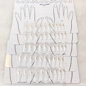 Könnte beinhalten: Klares Acryl-Nagel-Größen-Kit mit goldenen Zahlen 0-9. Das Kit enthält verschiedene Nagelformen: Mandel, Ballerina, Quadrat, Stiletto und Oval. Das Logo von Rose Smith ist oben sichtbar.