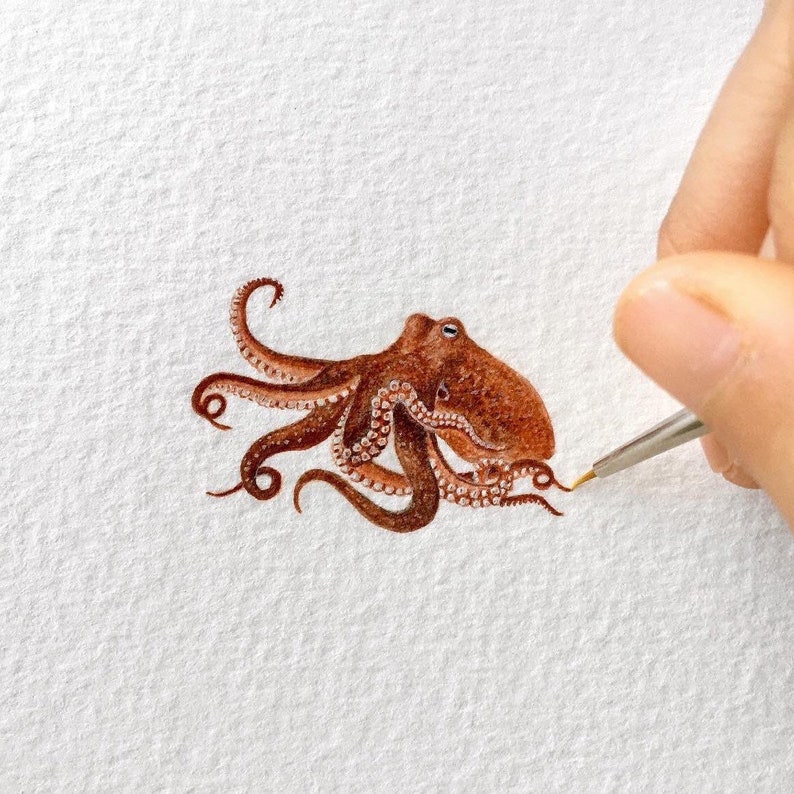 May include: A detailed watercolor painting of an octopus with brown and white coloring. The octopus is painted in a realistic style with its tentacles curled and extended.