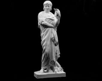 May include: A white matte sculpture of a standing figure draped in flowing fabric, holding a small vessel in the left hand. The figure has short hair and is positioned on a rectangular base, captured against a solid black background.