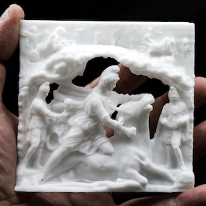 May include: A white 3D printed relief sculpture depicting a scene from Greek mythology. The sculpture features a man riding a bull, with other figures surrounding them.