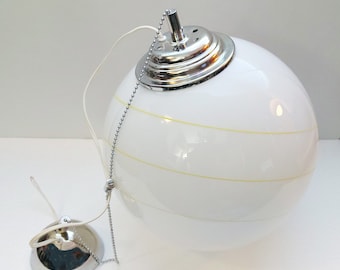 May include: A white globe pendant light with a chrome finish and a chain. The globe has yellow stripes.
