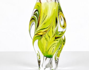 Puede incluir: Un jarrón de vidrio escultural y alto que presenta un patrón orgánico y arremolinado de color verde lima vibrante y vidrio transparente. El recipiente tiene una base gruesa y pesada con una silueta redondeada y asimétrica.
