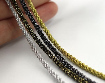 May include: Four spools of metallic cord in silver, gold, black, and a dark bronze colour. The cords are twisted and have a sparkly finish.