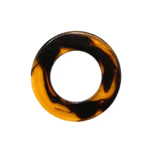 May include: A round, brown and black marbled ring with a hole in the center.