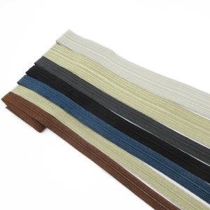 Peut inclure: Un ensemble de huit élastiques de couleurs différentes, chacun avec une texture côtelée. Les couleurs sont le brun, le beige, le bleu, le noir, le gris et le blanc.