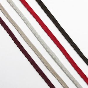 May include: Five parallel strips of decorative trim arranged diagonally. The colours include dark burgundy, light beige, off-white, bright red, and dark brown. Each trim features a flat woven base with a scalloped, raised edge detail.