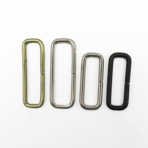 Peut inclure: Quatre boucles métalliques rectangulaires disposées en rangée. La première boucle est en laiton antique, la deuxième en argent poli, la troisième est une boucle argentée plus petite et la quatrième est noire mate. Chaque pièce a une couture visible.
