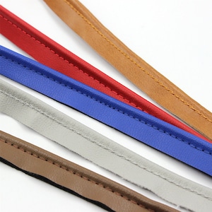 May include: Five different colors of leather cord with a stitched edge. The colors are brown, red, blue, gray, and brown.