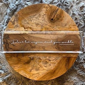 May include: A round wooden serving tray with a natural brown grain pattern, featuring a clear rectangular acrylic tray overlay with handles. The acrylic piece displays the white cursive text, Don't let anyone steal your sparkle.