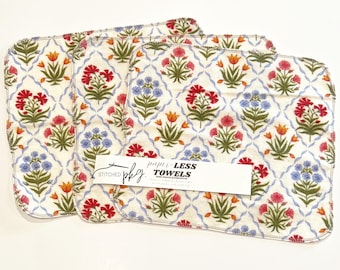 Könnte beinhalten: Drei quadratische, papierlose Handtücher mit einem Blumenmuster in Rot, Blau und Orange auf cremefarbenem Hintergrund. Die Handtücher haben ein sich wiederholendes Design aus Blumen und Blättern. Der Text "paper-LESS TOWELS" ist sichtbar.