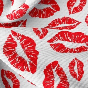 Puede incluir: Tela blanca con un patr&oacute;n repetido de labios rojos.