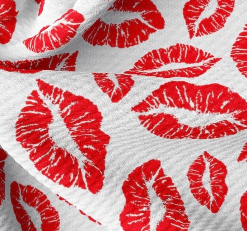 Puede incluir: Tela blanca con un patr&oacute;n repetido de labios rojos.