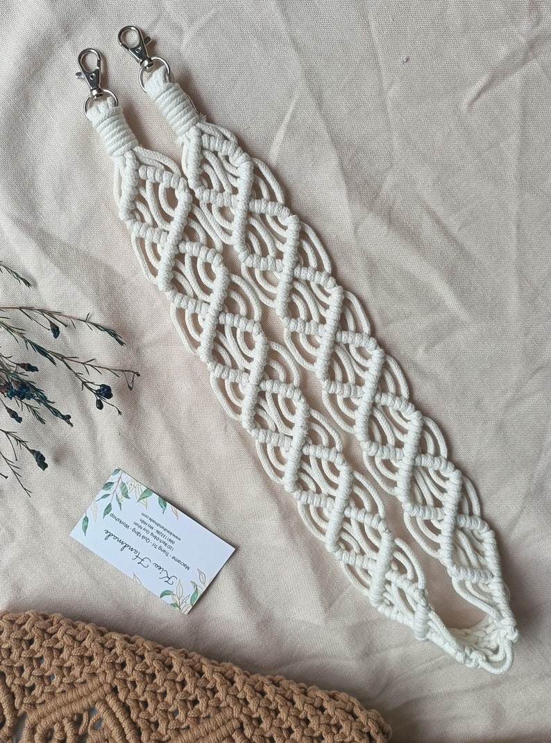 May include: White macrame bag strap with silver clasps. The strap is made of cotton cord and has a diamond pattern.
