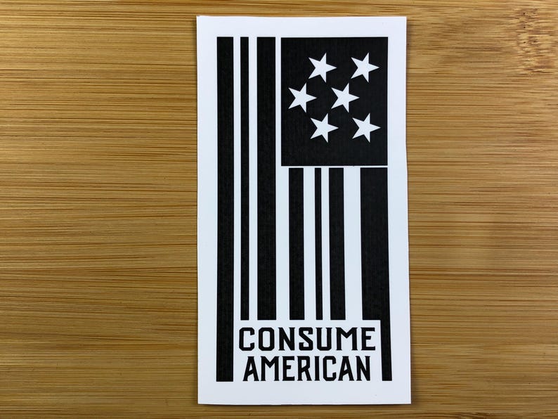 May include: Black and white sticker featuring a stylised American flag and the text "CONSUME AMERICAN".
