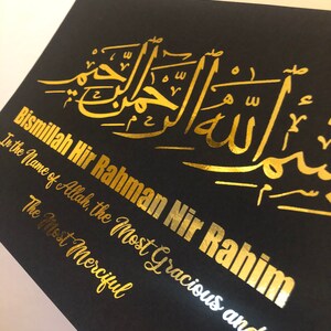 May include: A black background with gold lettering that reads "Bismillah Hir Rahman Nir Rahim" in Arabic script. The text translates to "In the name of Allah, the Most Gracious and The Most Merciful."