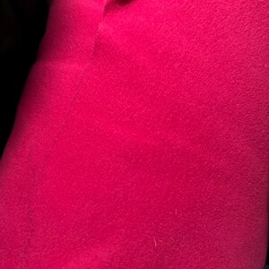 May include: Close-up of a bright pink fabric with a soft, fuzzy texture.