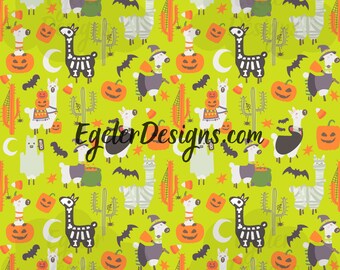 May include: A lime green fabric pattern featuring repeating illustrations of llamas dressed in Halloween costumes, orange pumpkins, cacti, bats, white crescent moons, and candy corn. The text EgelerDesigns.com is printed in black across the center.