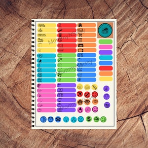 May include: A colorful set of 36 blank labels with various icons. The labels are arranged in rows on a white sheet of paper with a spiral binding. The icons include a school bus, a house, a mailbox, a tooth, a baseball, a soccer ball, a video game controller, a plane, a paw print, a light bulb, a phone, and a dollar sign.