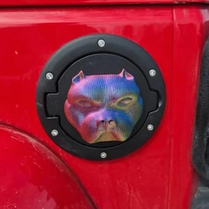 Könnte beinhalten: Eine schwarze Tankklappe mit einem 3D-gedruckten, regenbogenfarbenen Pitbull-Hundekopf-Design.