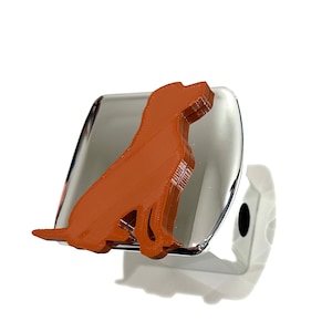May include: A chrome car hitch cover with a brown dog silhouette attached to it.